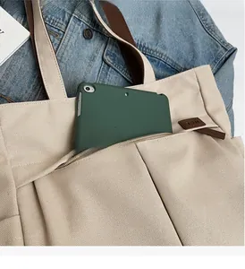 Detail of canvas tote bag with front zipper pocket showing large capacity storage