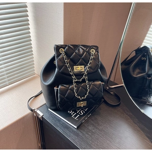 Detail of black quilted leather backpack with metal chain strap and twist lock