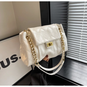 Detailed view of white quilted leather bag with gold clasp and chain strap luxury texture