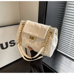 Detail of white quilted faux leather bag with gold chain strap and metallic twist lock