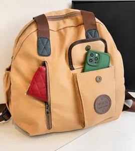 Detail view of khaki nylon backpack showing multiple storage pockets and inner organization