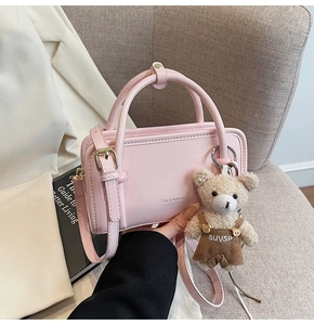 Detailed close-up of a pink mini crossbody bag with leather texture and bear charm