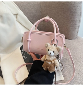 Chic pink rectangular crossbody bag with round handle and cute plush bear keychain