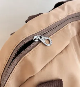 Detail of smooth metal zipper and khaki nylon fabric on large capacity backpack