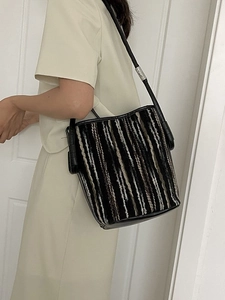 Colorful woven stripe bucket bag with black leather trim and silver hardware details