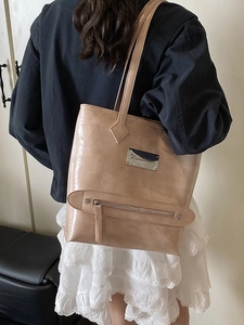 Minimalist beige glossy leather tote bag with metallic hardware for women's daily commute