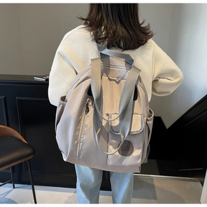 Side view of large khaki nylon backpack with multiple pockets and adjustable straps