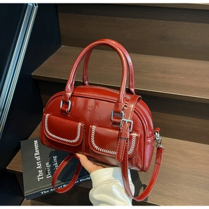 Dettaglio borsa Boston rossa retrò con finitura lucida e doppie tasche anteriori a patta