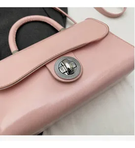 Detailed macro of pink glossy leather handbag with elegant silver round twist lock