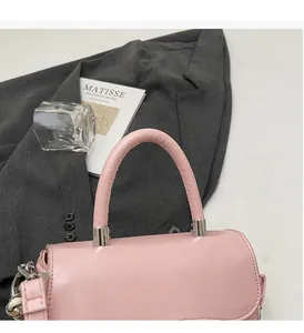 Detail of pink PU leather handbag showing reinforced handle and silver metal hardware