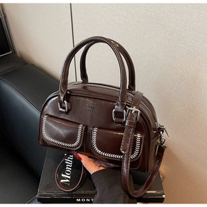 Dettaglio della borsa Boston marrone con cuciture bianche e logo in rilievo