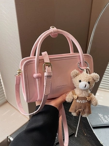 Pink faux leather mini handbag with top handles, shoulder strap and cute teddy bear charm