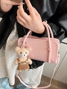 Pink rectangular crossbody handbag with plush bear charm and clearok embossed logo detail