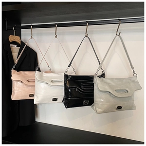 Selection of four bucket bags in pink, white, black, and gray on a metal display rack
