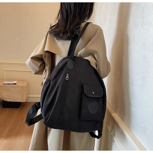 Detail view of large black waterproof nylon backpack with functional multi-pocket design