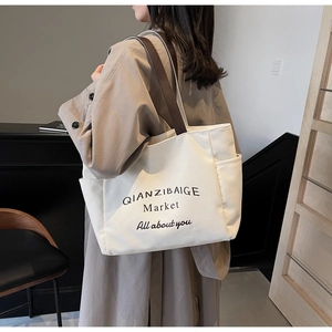 Gebroken witte canvas shopper met bruine handvatten en zijvak voor dagelijks gebruik