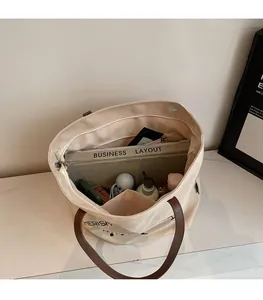 Detail view of large canvas tote bag interior with multiple pockets and zipper compartment