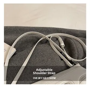 Detail of white leather tote with adjustable shoulder strap and brand logo label