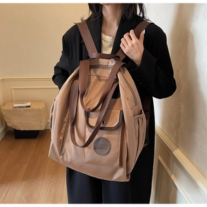 Nylon travel backpack with large capacity and multi-pocket design shown on model
