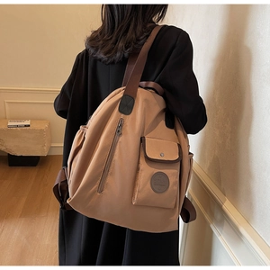 Side view of a khaki large-capacity oxford backpack shown on a model for travel