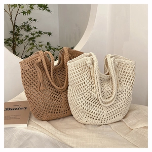 Close-up of handmade woven crochet tote bags with tassel details in summer beach style