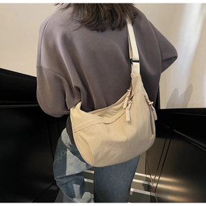 Beige nylon crescent bag detail showing large capacity and adjustable wide strap