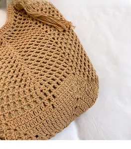 Detailed macro view of khaki hand-woven mesh texture with elegant tassel accent