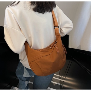 Detail of caramel nylon hobo bag with adjustable strap and braided zipper pulls