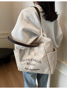 Grote gebroken witte canvas shopper met bruine lederen handvatten en zijvakken