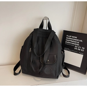 Detail of high-density black nylon backpack featuring waterproof texture and leather logo