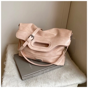 Detail of light pink soft faux leather bucket bag with top handle and adjustable strap