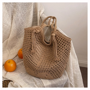 Close-up of handmade woven tote bag with hollow knit texture and stylish fringe detail