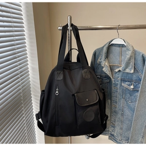 Detail of waterproof black nylon backpack with multi-pocket design and adjustable straps