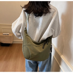 Rear view of an olive green nylon crescent bag showing large capacity and adjustable strap