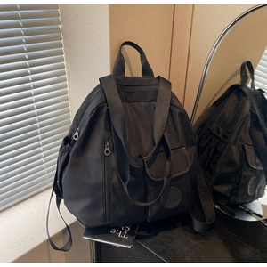 Detail view of large capacity black oxford backpack with multiple pockets and side bottle holder