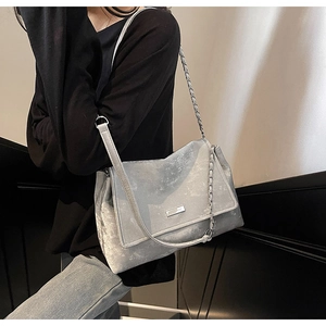 Close-up of the silver metallic shoulder bag with XYP logo and chain strap detail