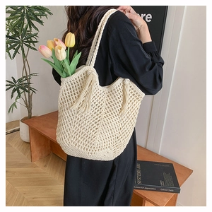 Detail of hand-woven crochet tote bag with long tassels and tulip flower interior