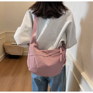 Pink nylon crescent crossbody bag shown on a model to display size and fit