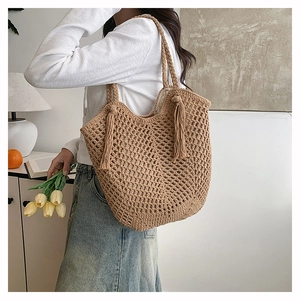 Close-up of brown crochet tote bag featuring fringe details and hollow woven pattern