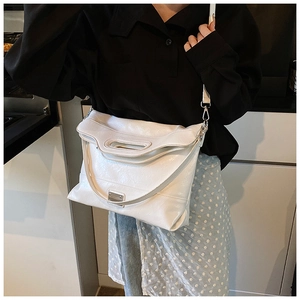Detailed close-up of the white leather bucket bag with textured pleats and silver hardware