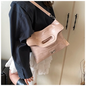 Detail of light pink tote bag with glossy pleated texture and cutout handle design