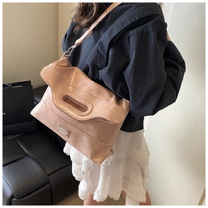 Detail of nude pink bucket bag with pleated texture and silver brand logo plate