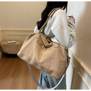 Detail of khaki suede tote bag featuring NINGJIA embossing and adjustable shoulder straps