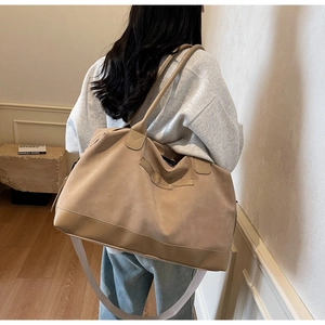 Grand sac cabas en suédine porté à l'épaule par un mannequin dans un décor épuré
