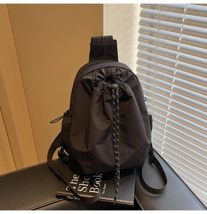 Gros plan du sac en nylon noir avec cordon de serrage et détails de fermeture éclair