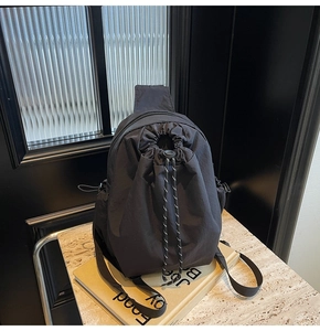 Gros plan d'un sac bandoulière en nylon noir avec cordon de serrage sur marbre