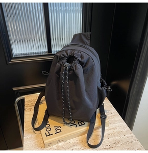 Détail d'un sac à dos noir avec cordon de serrage et sangles réglables en nylon robuste
