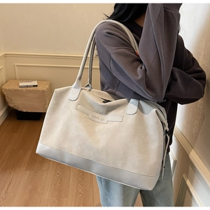 Détail d'un grand sac cabas gris avec texture en cuir mat et logo NINGJIA gravé