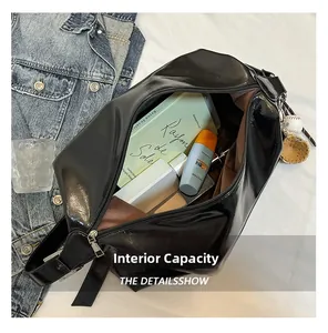 Detail showing the internal capacity and spacious brown lining of the black glossy tote bag
