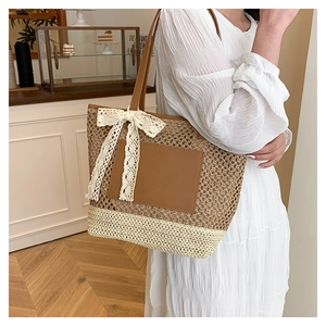 Détail du sac cabas en paille tissée avec patch en cuir marron et nœud en dentelle